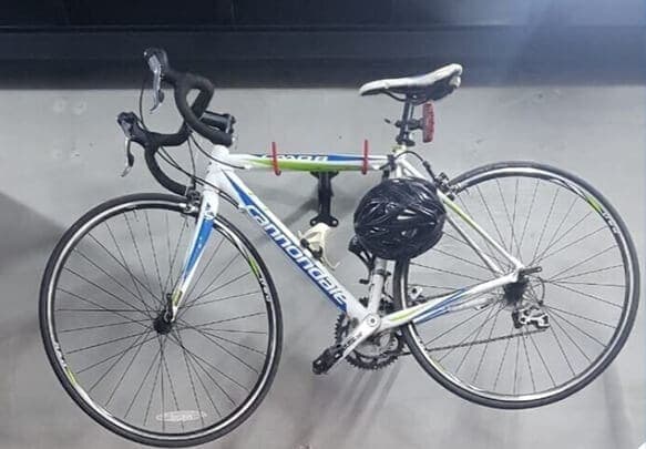 Road bike with its helmet parked against a wall inside a MyStorage facility