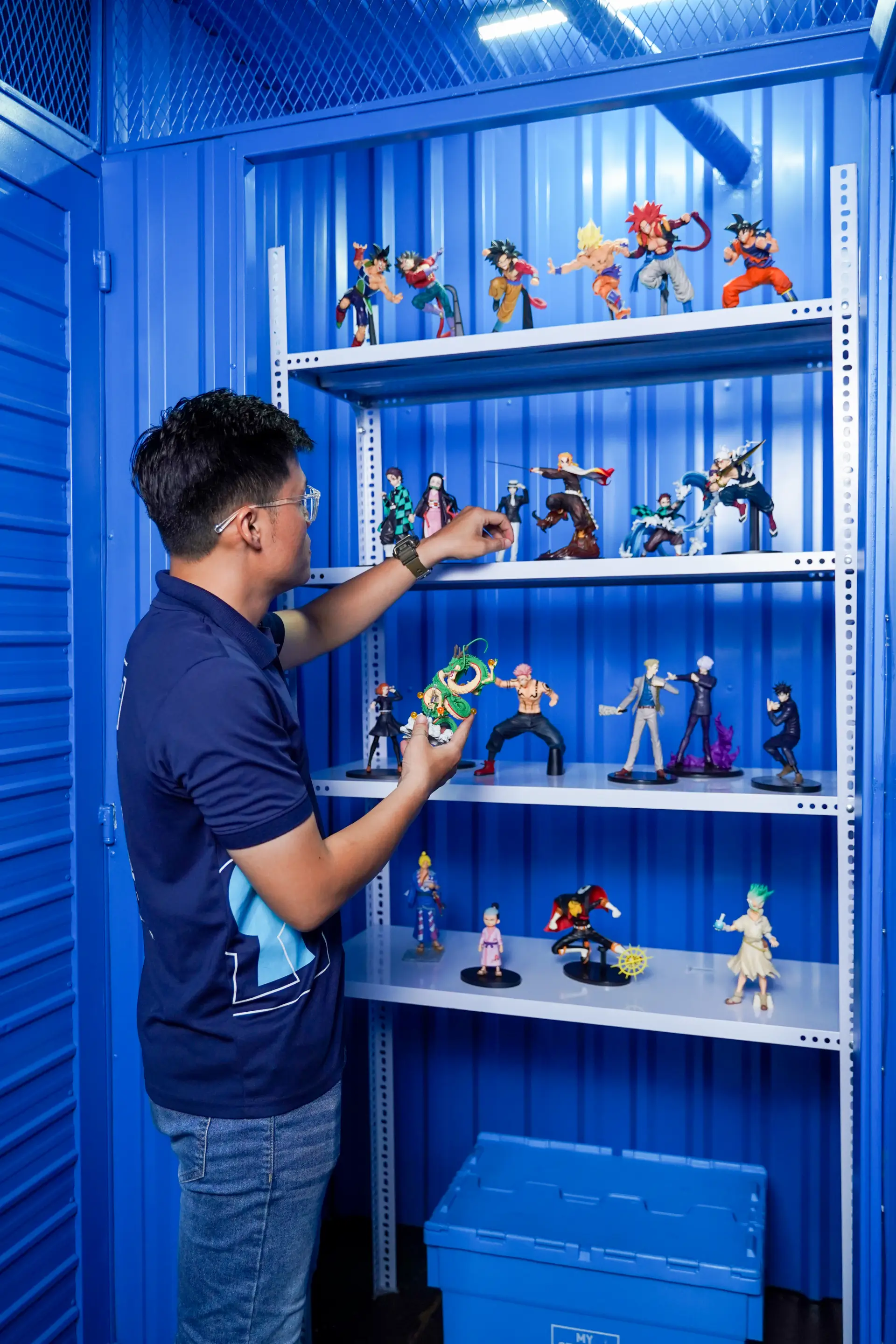 Man placing an anime figure into storage